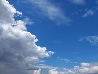 Obraz premium Clear blue sky with a few clouds. The sky is very bright and the clouds are scattered throughout in summer season