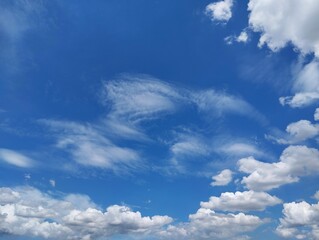 Obraz premium Clear blue sky with a few clouds. The sky is very bright and the clouds are scattered throughout in summer season