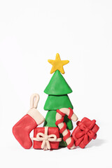 Plasticine New Year. A plasticine Christmas tree with gifts, Christmas stocking on a white background.