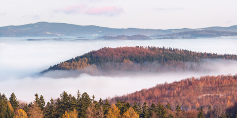Eastern Sudetes, thick fog in the valley between mountain peaks, mountain landscape on a mountain hiking trail.