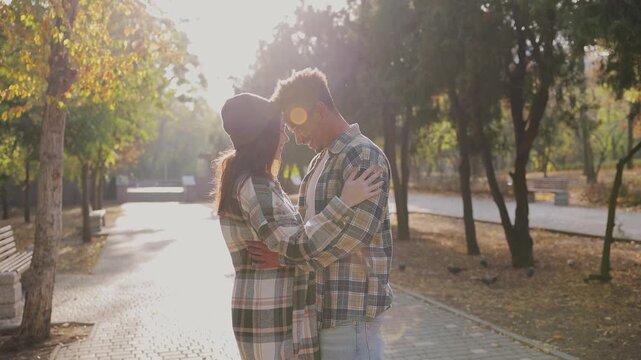 Side view young couple two friends family man woman wear casual clothes hug embrace touch forehead of each other walk relax in fall city park go down alley outdoors on nature. Urban leisure concept