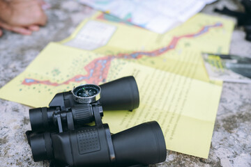 Binoculars and compass on map planning exploration