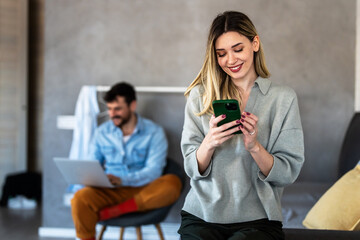 Smiling woman enjoys digital chatting, mobile communication at home, staying connected with friends