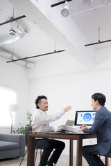 作業着の男性とスーツの男性が内装工事や施工など打ち合わせをする