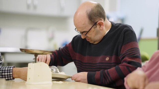 Man with a disability carefully weighing rice on an old-fashioned kitchen scale. Concept of dietary control, special needs, and nutrition
