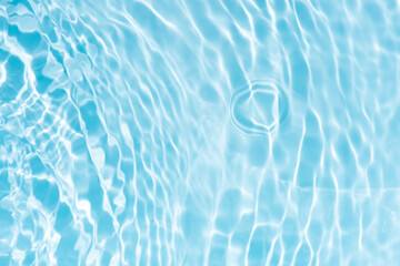 Obraz premium Blue water with ripples on the surface. Defocus blurred transparent blue colored clear calm water surface texture with splashes and bubbles. Water waves with shining pattern texture background.