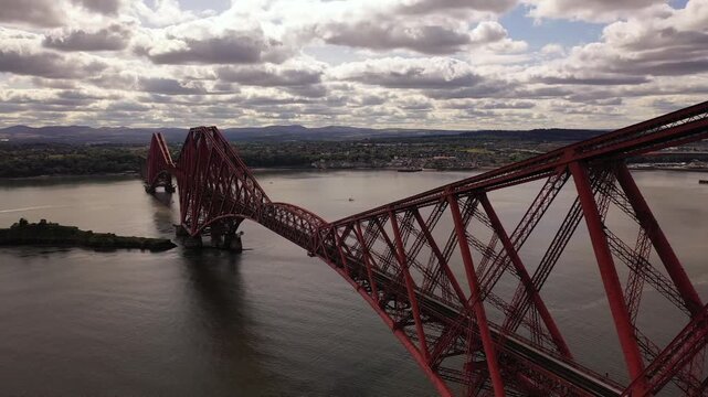 Aerial view of the striking red Forth Bridge spans the Firth of Forth, connecting the banks with its intricate steel structure, Inverkeithing, Scotland, United Kingdom.