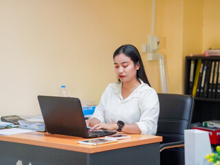 Candid business people using laptop and phone technology collaborative spaces at workplaces. Asian Businesswoman browsing internet working. Female leadership remote work goal planning new beginning 