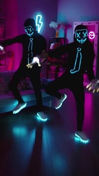 Halloween neon masked dancers filming night dance video on phone glowing costume party style viral short video performance