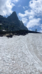 Mountain River Flowing Through a Rocky Alpine Gorge with Snow-Capped Peaks