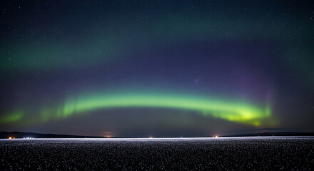 Wide shot of night sky with bright aurora over a snowy field, suggesting ethereal beauty, natural wonder, and the magic of the arctic region