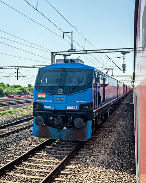 Green flags exchanged as Con-Cor container goods train with WAG-12B waits for the crossing of duronto epress