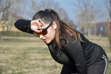 Woman with visual disabilities exercising in the park and stretching