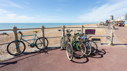 Brighton, united kingdom, 23, August 2022 Colorful Bicycle Rack On Seaside Promenade With Pebble Beach And Clear Blue Sky