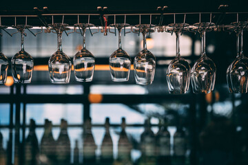 Close-up of Clean Wine Glasses Hanging on a Rack in a Stylish Bar
