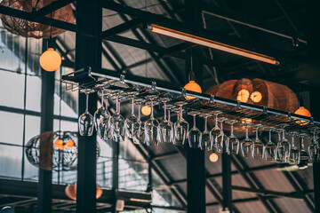 Rows of Wine Glasses Hanging in a Modern Industrial Bar with Warm Lighting