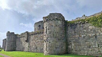 Stone walls and round defensive towers of Beaumaris Castle in Anglesey, Wales, a UNESCO World Heritage medieval fortress built by Edward I, captured under soft daylight with historic masonry details.