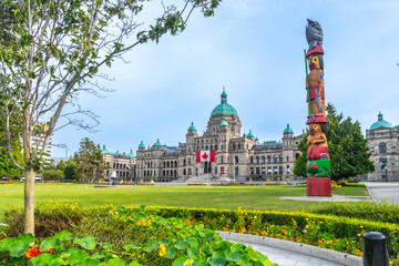 Totem pole standing proudly in front of parliament buildings in victoria, british columbia