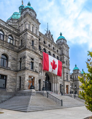 Fototapeta premium Canadian flag hanging on parliament building in victoria, british columbia