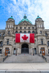 Naklejka premium Canadian flag flying at the british columbia parliament buildings in victoria