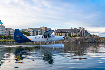 Seaplane taking off in victoria harbor with waterfront buildings in background