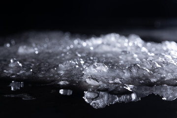 Snow and ice close-up on a dark background. Abstract winter background.