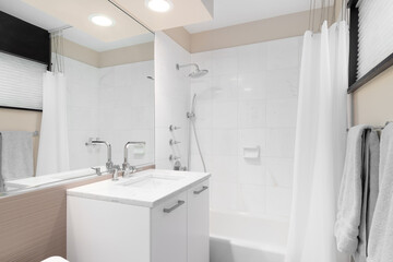 A clean and modern brown bathroom featuring a white vanity and sink, bathtub, and shower with a white curtain and white square tiles. 