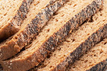 Slices of rye bread covered with poppy and sesame seeds close-up. Food background.