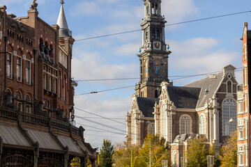 Picturesque view of Westerkerk in Amsterdam lit up by soft autumn light rising above the streets of Dutch capital city