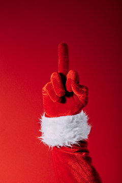 Santa Claus Hand in Red Glove Making Rude Middle Finger Gesture