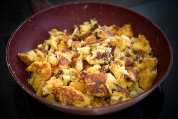 cooking a austrian speciality, a kaiserschmarrn with raisins and apple