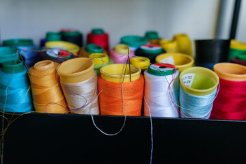 Colorful threads in seamstress workshop