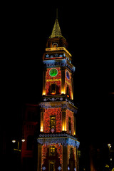 Illuminated Clock Tower with Festive Holiday Lights at Night