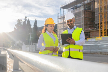 Construction engineers reviewing site plans on tablet