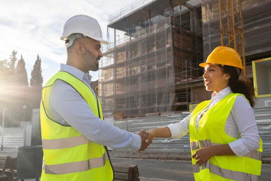 Engineers shaking hands on building site