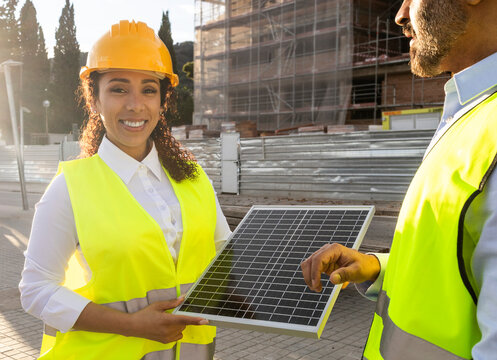 Engineers discussing solar panel at construction site