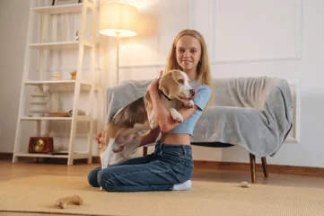 Fotobehang Ridders Casual time spending, wellness. Girl is with her dog on the floor in a cozy living room  © standret