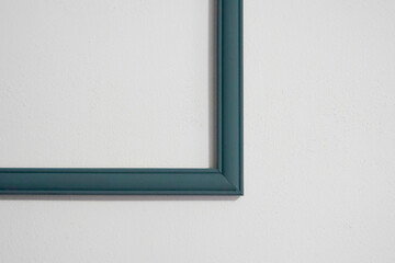 Fototapeta premium empty dark turquoise frame on a white wall