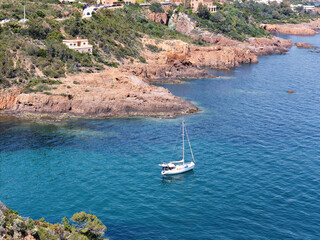 Steep coast on the Cote d'Azur, French Riviera, overlooking the open Mediterranean Sea to the sailing ship, drone photo