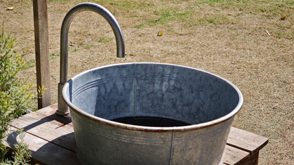 A hand washing place shaped like a wooden drum barrel in a park.
