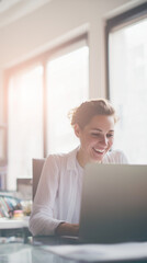 Joyful female entrepreneur receiving positive news on laptop by a window