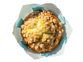 Isolated delicious crumb cake topped with creamy filling in blue paper, ready to be eaten