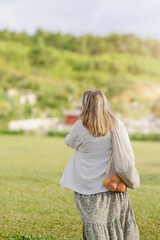 Obraz premium Caucasian mature woman walking outdoors with eco-friendly bag in nature