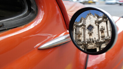  Reflected in the mirror of a classic 1950's car. is the Havana Cathedral located in the Plaza de la Catedral . Old Havana, Havana, Cuba..