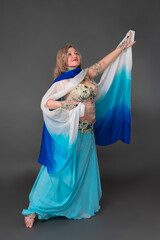Middle aged adult woman belly dancer dressing in dancing stage costume performing in full length