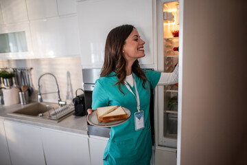 Smiling nurse taking lunch break in modern kitchen