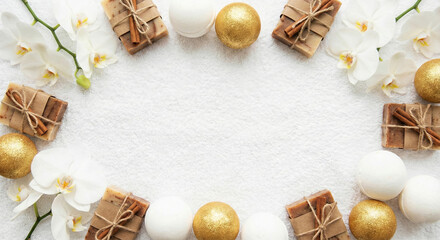 Bath bombs and soap are arranged with white orchids on white fabric.