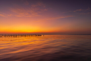 Obraz premium The view of the wooden bridge and the sea at sunrise,beautiful sea bridge image, panorama, background