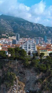 4K aerial vertical video of Saint Nicholas Cathedral on the Rock of Monaco. Cinematic drone footage of historic church on cliff with mountains background. Iconic travel landmark for mobile reels.