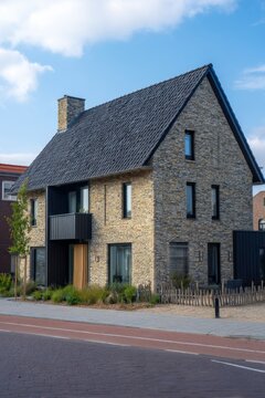 A contemporary building proudly lines a sunny street within a charming residential neighborhood, where clear blue skies are dotted with a few fluffy clouds